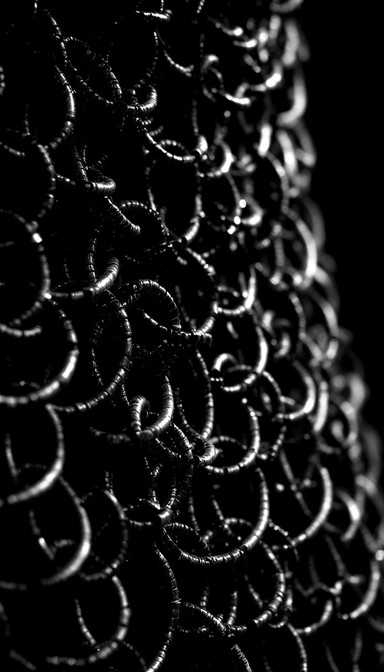 Weathered medieval chainmail armor showcases interlocking metal rings ...
